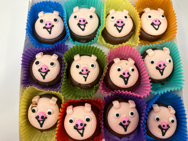 Oreo's with animal face designs in colorful paper liners on a white surface